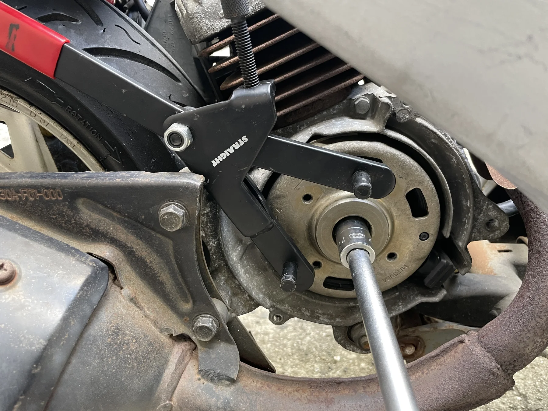 ユニバーサルホルダーでAF27のフライホイールを固定して中央ナットを外す作業